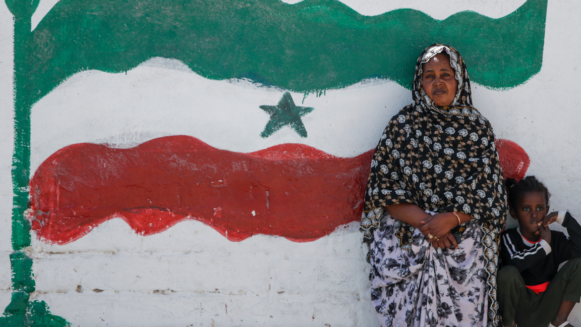 Жена и дете пред знамето на сомалийския сепаратистки полуавтономен район Сомалиленд в главния град на региона Харгейса, 9 февруари 2022 г.